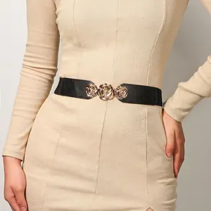 Detail der eleganten Goldrosen-Metallschnalle an einem schwarzen elastischen Taillengürtel