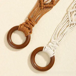 Détail de ceinture tressée bohème avec incrustation de coquillages et boucle en bois