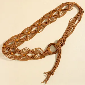 Détail d'une ceinture tressée bohème avec des perles en bois et des finitions à glands