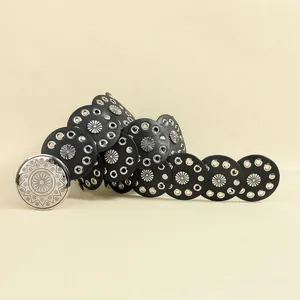 Detail view of vintage bohemian belt with sunflower rivets and ornate silver metal buckle