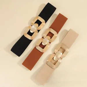 Three wide elastic waist belts in black brown and beige with golden geometric buckles