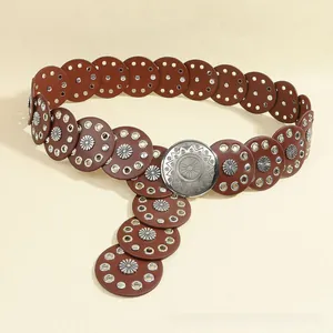 Detail of bohemian round disc leather belt with silver floral rivets and sunburst buckle
