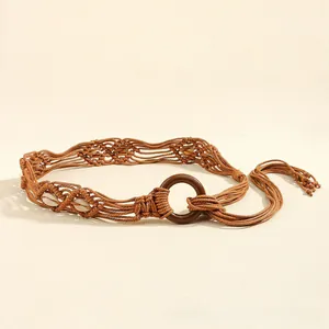 Détail de ceinture tressée bohème avec boucle en bois, coquillages et longues franges