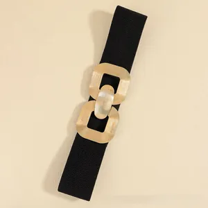 Detail of wide elastic waist belt featuring a textured gold double ring metal buckle