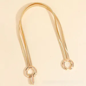 Detail of elegant gold double-layered spring waist chain with interlocking geometric buckle