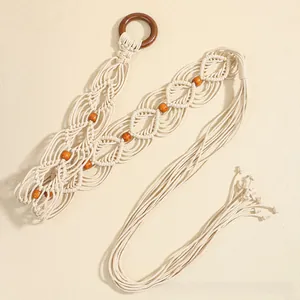 Détail d'une ceinture tressée bohème en coton crème avec anneau en bois et perles brunes