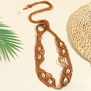 Détail de la ceinture bohème tressée avec anneau en bois, coquillages et style plage