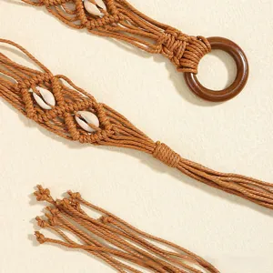 Détail de la ceinture tressée bohème avec coquillages blancs et boucle en bois ronde