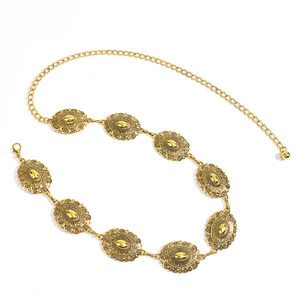 Close-up of vintage gold metal waist chain with embossed bohemian oval medallions