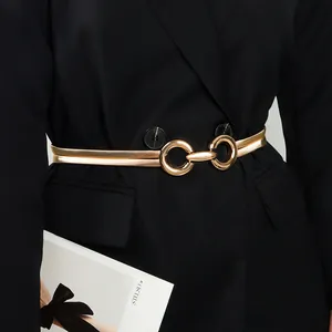 Detail of elegant gold double-layered spring waist chain with geometric buckle on black suit
