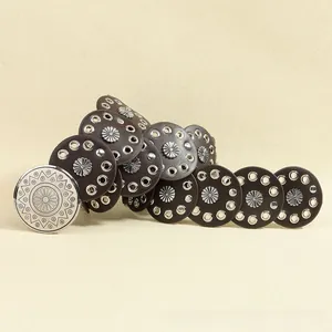 Close-up of bohemian brown leather waist belt with sunburst studs and silver round buckle