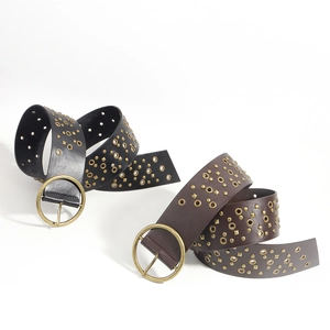 Detail of vintage wide belts in black and brown leather with studs and round gold buckles
