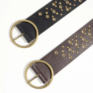 Detail of vintage leather belts featuring brass grommets and pyramid studs with metal buckles