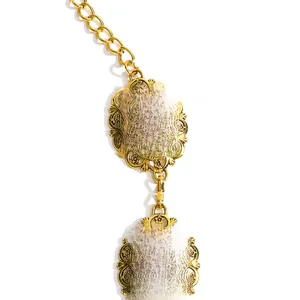 Macro shot of retro gold hollowed-out carved oval plates on a metallic waist chain