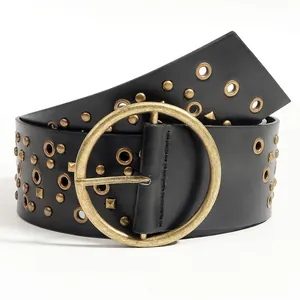 Detail of wide black leather belt featuring vintage gold rivets and a large round buckle