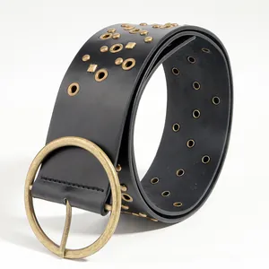 Close-up of a punk style black belt featuring gold eyelets and vintage metal buckle