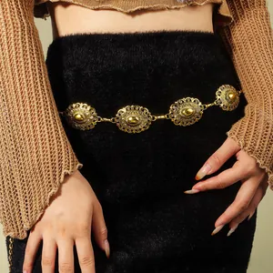 Detail of vintage gold metal waist chain featuring ornate carved floral relief patterns