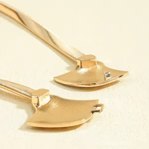 Detailed view of bohemian gold metal fan-shaped buckle and elastic chain belt texture