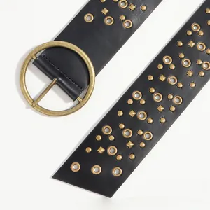 Detail of black faux leather belt with vintage bronze studs and round metal buckle