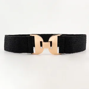 Détail d'une ceinture élastique noire pour femme avec une boucle géométrique en métal doré