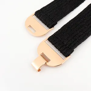 Détail d'une ceinture élastique noire avec boucle métallique demi-cercle dorée