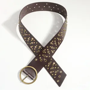 Detail of vintage wide brown leather belt featuring antique brass studs and large round buckle