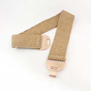 Détail de la ceinture tressée élastique kaki avec une boucle demi-lune en métal doré