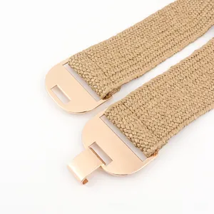 Détail d'une ceinture tressée kaki avec boucle métallique emboîtable en or rose