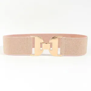 Détail de ceinture élastique rose champagne avec boucle double D dorée entrelacée