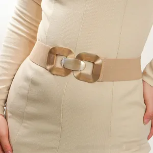 Close-up of golden geometric double-ring buckle on a beige elastic waist belt for dresses