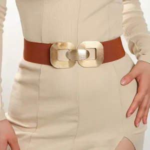 Close-up of brown elastic waist belt with textured gold double ring geometric buckle