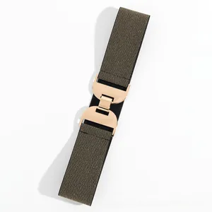 Gros plan de la ceinture élastique tissée avec une boucle métallique géométrique dorée polie