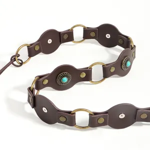 Detail of vintage brown leather belt with turquoise studs and sunburst metal rivets