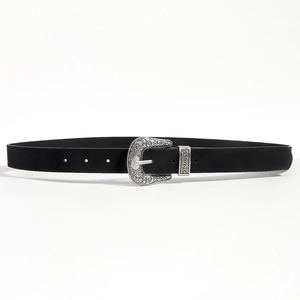 Close-up of vintage engraved silver-tone metal buckle on a black synthetic leather belt
