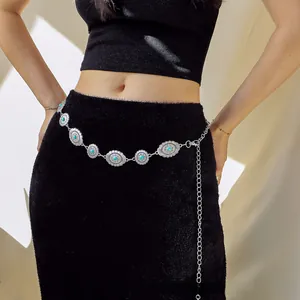 Detail of bohemian silver waist chain with turquoise inlays on black dress fabric