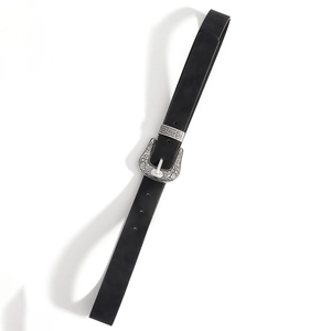Detailed close-up of vintage engraved silver metal buckle on a black leather belt