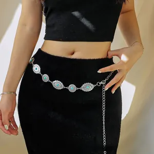 Macro detail of Bohemian silver waist chain with turquoise stones and engraved floral patterns