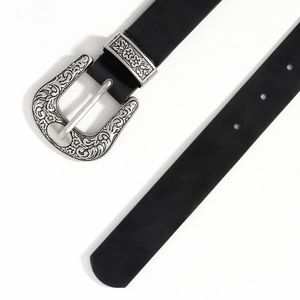 Detailed close-up of retro silver engraved metal buckle on a black leather belt