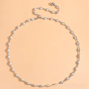 Détail macro de l'élégante chaîne de taille en perles avec maillons en métal argenté