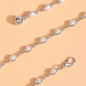 Détail de la chaîne de taille en perles argentées avec fermoir mousqueton et boule polie