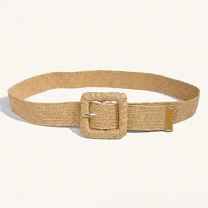 Close-up of beige woven straw belt featuring a classic square buckle and textured weave