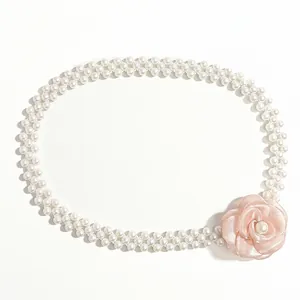 Detail of elegant double-row pearl belt featuring a pink camellia flower ornament