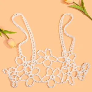 Exquisite handmade white pearl beaded camisole with floral hollow pattern on orange background