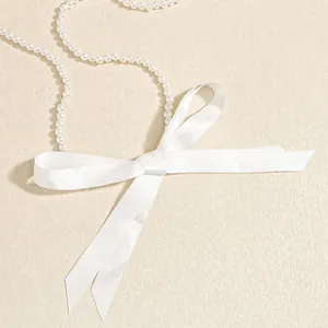 Dettaglio del fiocco di raso bianco con perle lucide per decorazione a catena incrociata