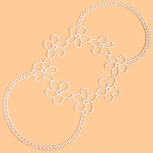 Detail of floral beaded vest accessory with white pearls on a peach background