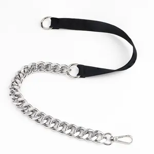 Detail view of stylish belt chain with silver curb links and black woven fabric strap
