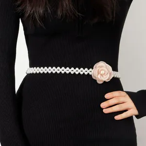 Detailed view of camellia pearl waist chain featuring double-row pearls and a pink fabric rose