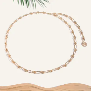Détail de la ceinture chaîne dorée à trombone avec pendentif rond en métal doré chic