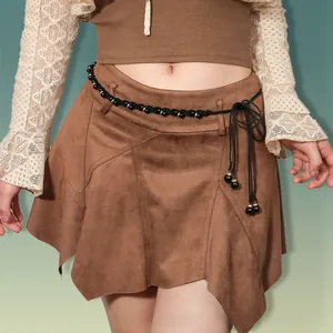 Close-up of brown suede mini skirt featuring irregular hem and black beaded woven belt