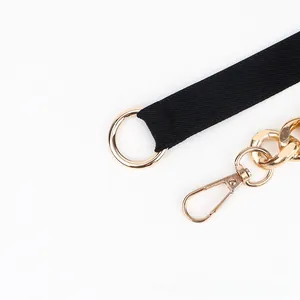 Detail view of black elastic belt with polished gold metal rings and lobster clasp